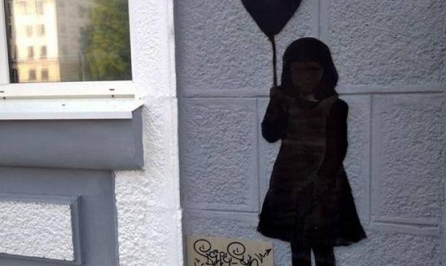 Дівчинка з кулькою і медведик у пам“ять: на запорізьких будинках з’явилися стріт-арти з підсвічуванням фото
